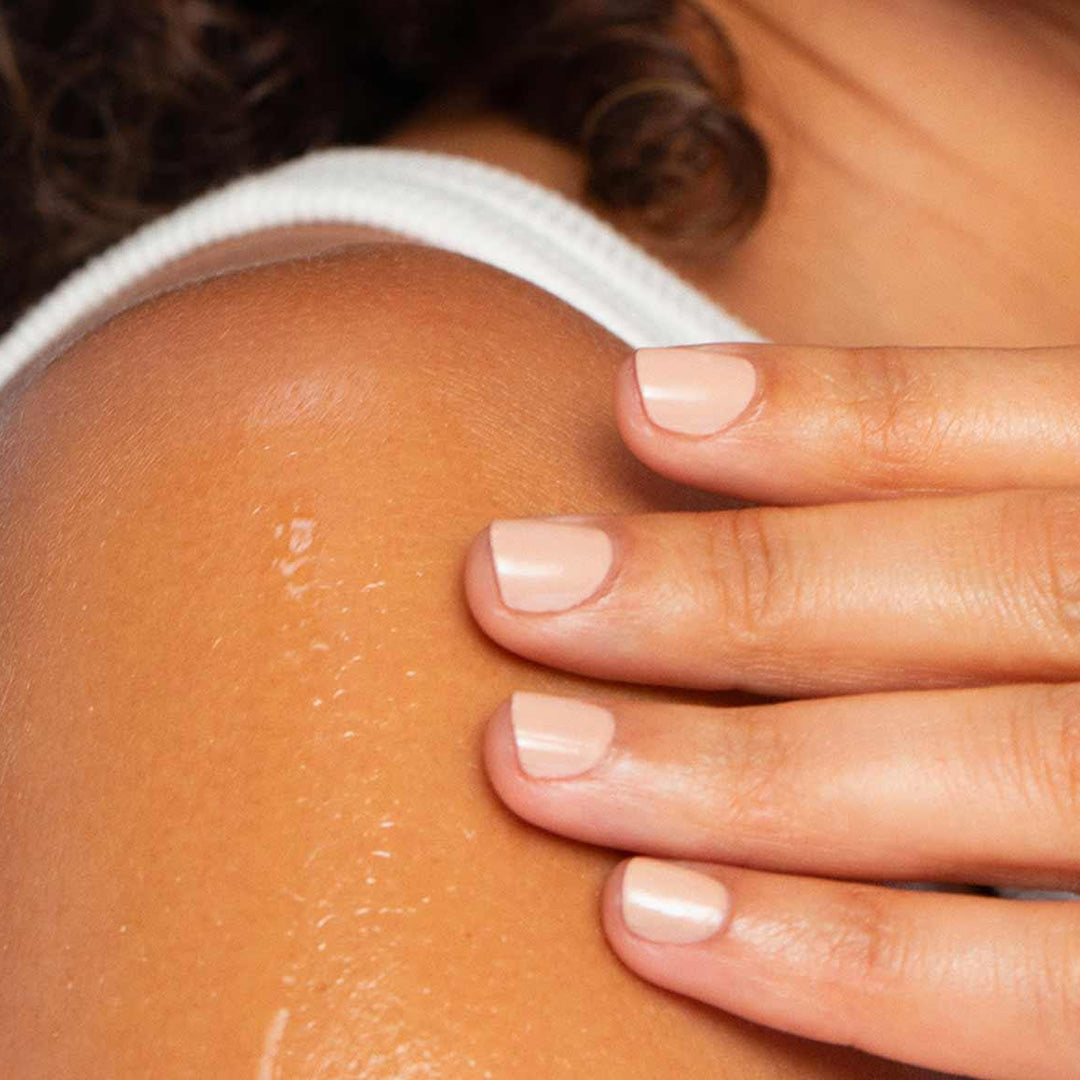 The Full Monty body oil applied on shoulder for deep hydration and radiant skin glow after shower