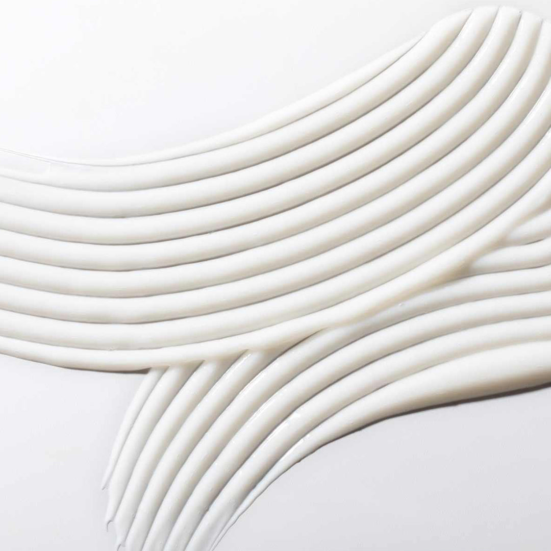 Close-up of white, wavy cream  gel patternon a light gray background