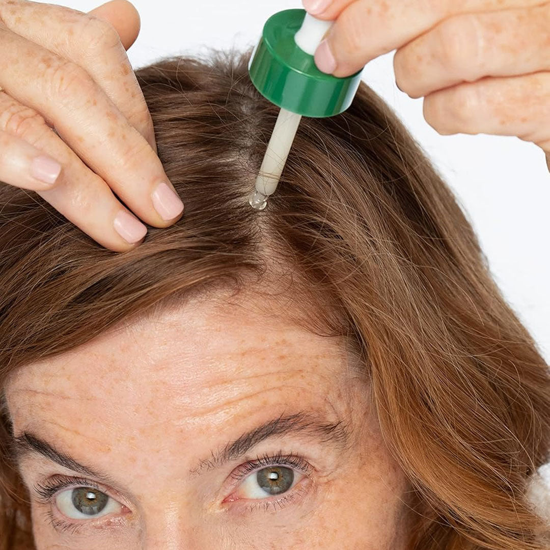 Meno Hair Essentials applying hydrating serum to scalp to improve hair density and nourish dry hair.