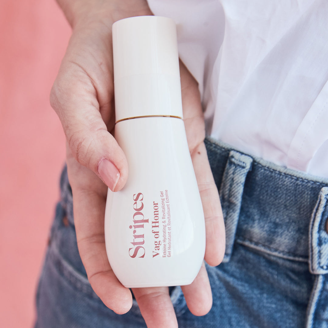 Stripes Beauty Vag of Honor intimate care bottle held by person wearing white shirt and blue jeans