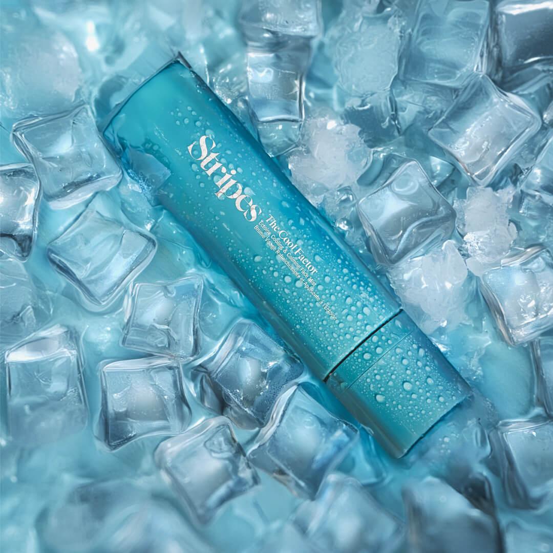 The Cool Factor refreshing mist bottle surrounded by ice cubes to emphasize cooling hydration benefits.